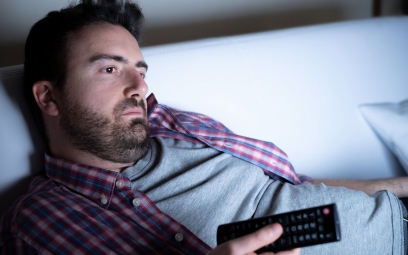 Male bored watching TV during self isolation