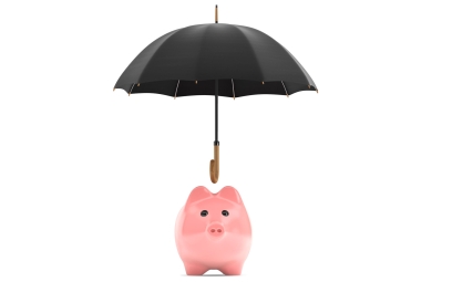 Umbrella over piggy money bank protecting savings