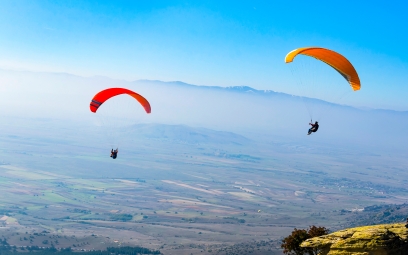 business success paragliding duo on a blue skyline